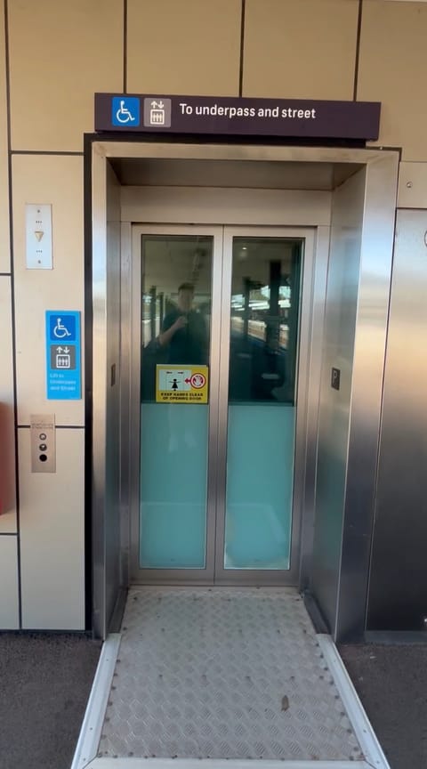On a platform, the lift signed "To underpass and street", with a level threshold plate at the door